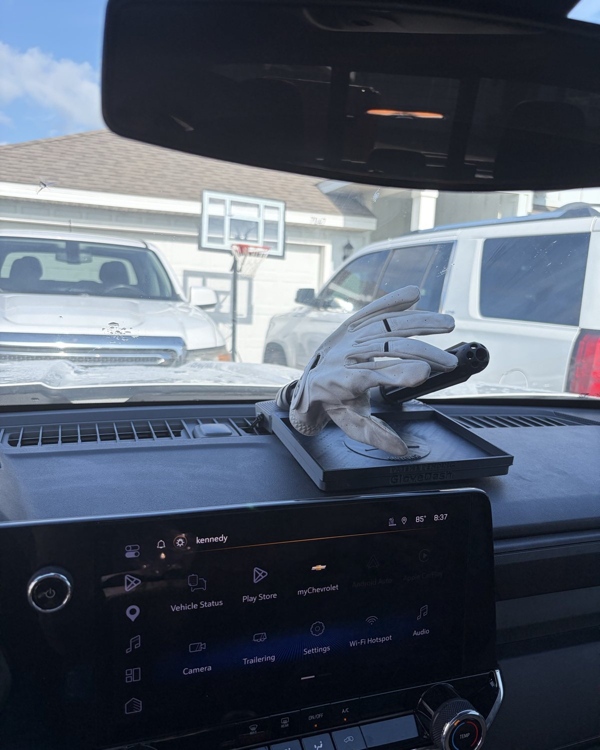 A white work glove drying on a black GloveDash tube on Kennedy's dashboard